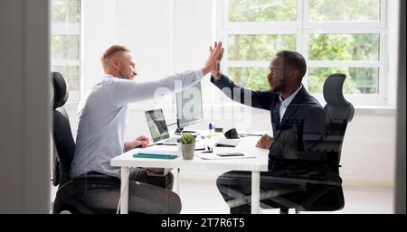 Deux jeunes hommes d'souriant, offrant un rapport cinq In Office Banque D'Images