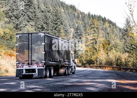 Industriel blanc capot long transporteur porte-bagages big rig semi-camion transportant des marchandises commerciales en noir sec van semi-remorque fonctionnant sur le support sinueux Banque D'Images