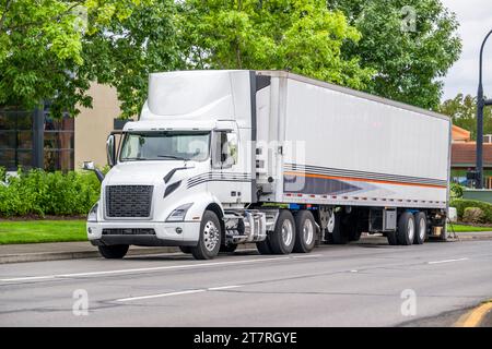 Transporteur local industriel semi-camion blanc big rig livrant la cargaison dans le réfrigérateur semi-remorque avec plate-forme de levage abaissée debout sur le U. Banque D'Images