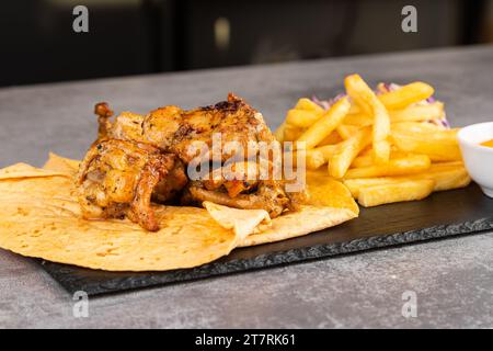 Poulet kebab avec légumes, frites et sauce sur lavash Banque D'Images