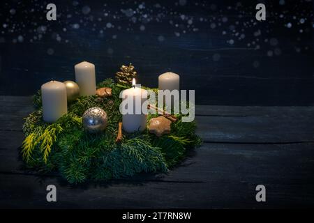 Couronne verte de l'AVENT avec des bougies blanches, on est allumé pour le premier AVENT, décoration de Noël et biscuits, fond en bois bleu foncé avec bokeh étoile, co Banque D'Images