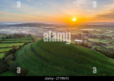 Glastonbury, Somerset, Royaume-Uni. 17 novembre 2023. UK Météo. Un lever de soleil spectaculaire derrière St Michael’s Tower sur Glastonbury Tor à Glastonbury dans le Somerset par un matin clair et froid. Crédit photo : Graham Hunt/Alamy Live News Banque D'Images