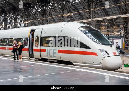 Un inspecteur vérifie le billet électronique d’une jeune femme devant un train à grande vitesse ICE de la Deutsche Bahn à la gare centrale de Francfort, en Allemagne. Banque D'Images