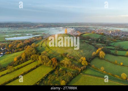 Glastonbury, Somerset, Royaume-Uni. 17 novembre 2023. UK Météo. Couleurs d'automne sur les arbres à Glastonbury Tor à Glastonbury dans le Somerset par un matin clair et froid avec une brume légère peu après le lever du soleil. Crédit photo : Graham Hunt/Alamy Live News Banque D'Images