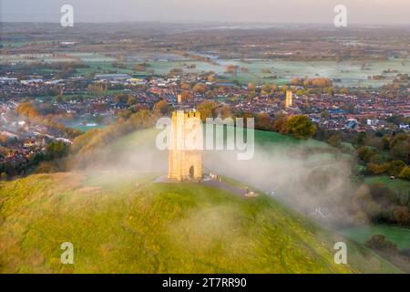 Glastonbury, Somerset, Royaume-Uni. 17 novembre 2023. UK Météo. Couleurs d'automne sur les arbres à Glastonbury Tor à Glastonbury dans le Somerset par un matin clair et froid avec une brume légère peu après le lever du soleil. Crédit photo : Graham Hunt/Alamy Live News Banque D'Images