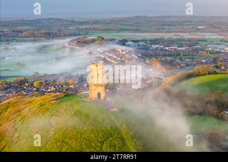 Glastonbury, Somerset, Royaume-Uni. 17 novembre 2023. UK Météo. Couleurs d'automne sur les arbres à Glastonbury Tor à Glastonbury dans le Somerset par un matin clair et froid avec une brume légère peu après le lever du soleil. Crédit photo : Graham Hunt/Alamy Live News Banque D'Images