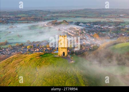 Glastonbury, Somerset, Royaume-Uni. 17 novembre 2023. UK Météo. Couleurs d'automne sur les arbres à Glastonbury Tor à Glastonbury dans le Somerset par un matin clair et froid avec une brume légère peu après le lever du soleil. Crédit photo : Graham Hunt/Alamy Live News Banque D'Images