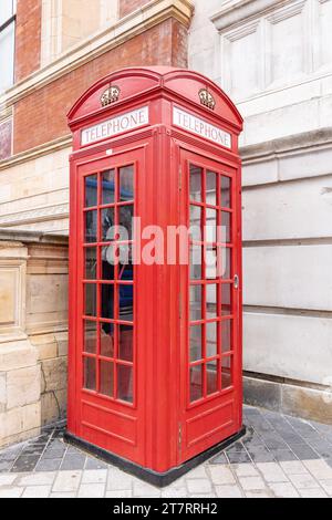 Cabine téléphonique londonienne. Un téléphone rouge emblématique dans la cabine londonienne dans une rue de la ville Banque D'Images