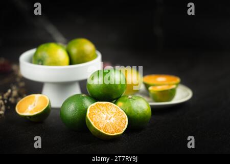 Oranges placées sur une dalle de marbre noir. Banque D'Images