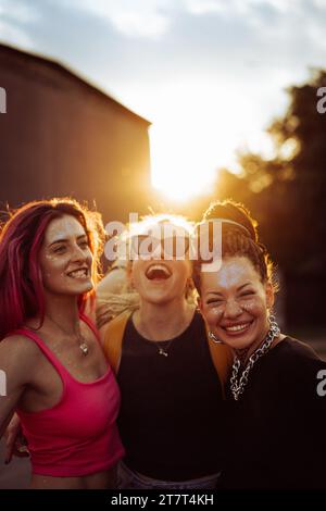 Trois amies heureuses au coucher du soleil, portrait émotionnel, amitié. Banque D'Images