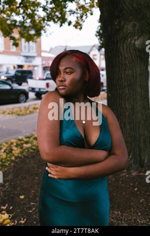 Modèle noir féminin en robe verte dans la zone urbaine du centre-ville Banque D'Images