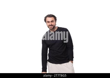 jeune homme brunette caucasien bien entretenu avec une barbe est vêtu d'un col roulé noir Banque D'Images