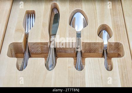 Argenterie brillante dans un plateau en bois craquelé dans le tiroir de table de service vue rapprochée supérieure. Rangement confortable pour la conservation des couverts Banque D'Images