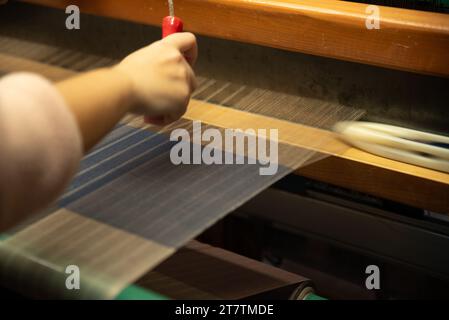 Fabrication textile traditionnelle fil de tissage pour l'industrie textile. Extrait, soie tissée, utilisant le coton et la soie stretch et tissé en utilisant mec Banque D'Images