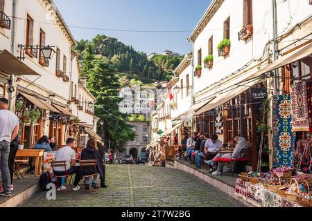 Boutiques de souvenirs et restaurants dans la vieille ville de Gjirokaster en Albanie. La vieille ville de Gjirokaster est un site du patrimoine mondial par l'UNESCO. Les gens se détendent et Banque D'Images