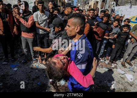 Rafah, Territoires palestiniens. 17 novembre 2023. Un palestinien transporte une jeune fille blessée à la suite d ' une frappe aérienne israélienne contre une maison du camp de réfugiés de Shaboura. Crédit : Abed Rahim Khatib/dpa/Alamy Live News Banque D'Images