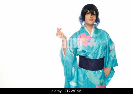 jeune homme en perruque extravagante et kimono montrant un mini geste de coeur avec les doigts sur blanc, cosplayer Banque D'Images