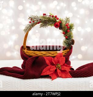 Panier de Noël vide avec écharpe rouge et décorations festives. Fond de Noël pour la conception. Composition du nouvel an sur fond lumineux avec bokeh l Banque D'Images