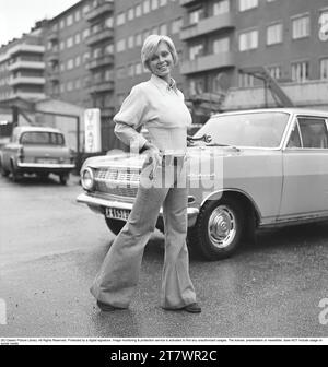 La mode des années 1970 Une jeune femme portant la mode typique des années 1970, un pantalon à jambes larges. Un style appelé Bell-bottols ou fares, pantalons qui s'élargissent des genoux et vers le bas, formant une forme de cloche de la jambe du pantalon. 1971. Kristoffersson réf. EF65 Banque D'Images