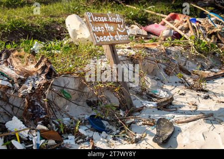 Panneau indiquant ''s'il vous plaît garder la plage propre'' et pile de différents plastiques et déchets Banque D'Images