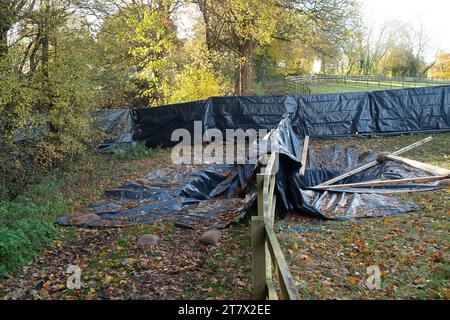 Hyde Heath, Royaume-Uni. 17 novembre 2023. Un gouffre géant HS2 est apparu dans le sol sur des terres agricoles et sous un sentier public / passerelle à Hyde Heath, Buckinghamshire. Le gouffre est au-dessus de l'endroit où HS2 creusent des tunnels pour le chemin de fer High Speed Rail 2. Le gouffre a maintenant été recouvert de plastique noir et est surveillé par HS2. Heureusement, personne n'a été blessé quand cela s'est produit. Un autre gouffre est apparu à Shardeloes près d'Amersham plus tôt cette année qui a maintenant été rempli par HS2. Crédit : Buckctrypics/Alamy Live News Banque D'Images