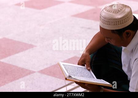 Homme musulman lisant un Coran, Ho Chi Minh ville, Vietnam, Indochine, Asie du Sud-est, Asie Banque D'Images