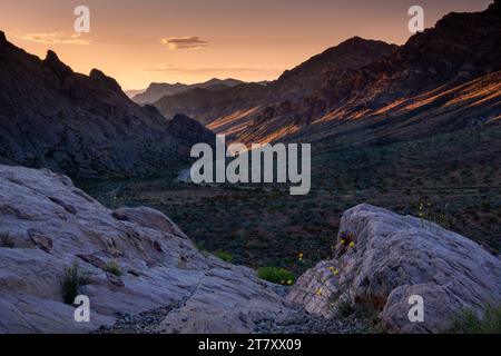 Le lever du soleil illumine le col à travers les montagnes à l'entrée ouest du parc d'État de la Vallée de feu, Nevada, États-Unis d'Amérique, Banque D'Images