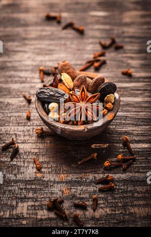 Épices de Noël pour la cuisson des biscuits, Stollen ou vin chaud dans un petit bol sur fond en bois. Banque D'Images