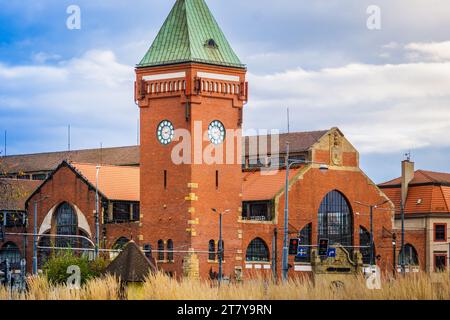 Wrocław, Pologne - 16.11.2023 : Wrocław Market Hall (Hala Targowa) structure du début du 20e siècle où les marchands fournissent des produits de boulangerie, de la viande, des fruits frais, Banque D'Images