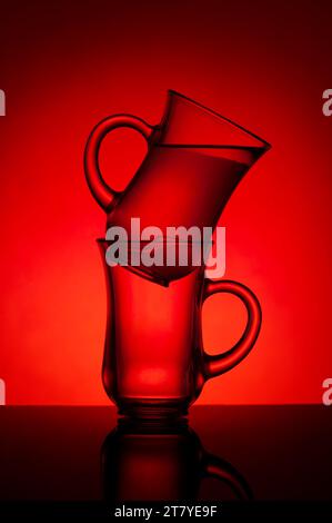 Verres pour le thé sur fond rouge. Des verres sont sur la table. Buvez. Fond rouge. Rétroéclairage. Banque D'Images