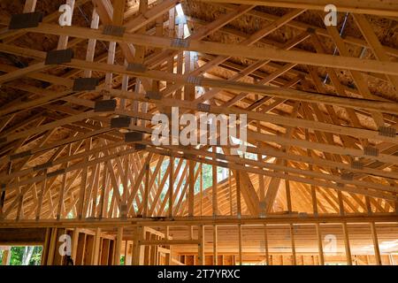 Les chevrons en bois au-dessus du futur espace de vie sur un nouveau chantier de construction de maison. Banque D'Images