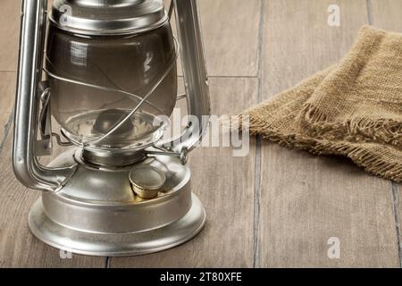 Une vieille lampe à kérosène avec du verre fumé recouvert de poussière sur une table Banque D'Images