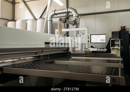 Une machine moderne pour couper des dalles de ferrures de meubles. Fabrication de meubles. Banque D'Images