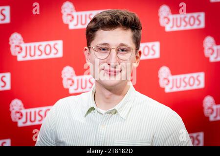 Brunswick, Allemagne. 17 novembre 2023. Philipp Türmer, nouveau président national de Jusos, se tient devant un mur de photos au congrès national des jeunes socialistes (Jusos). Crédit : Moritz Frankenberg/dpa/Alamy Live News Banque D'Images