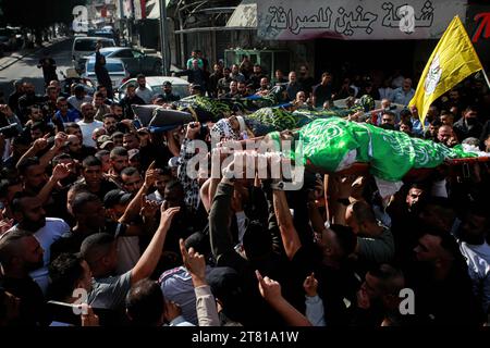 Djénine, Palestine. 17 novembre 2023. (NOTE DE l'ÉDITEUR : l'image représente la mort) les personnes en deuil portent les corps de trois Palestiniens drapés dans les drapeaux du Hamas et du Jihad islamique pendant leurs funérailles dans le camp de réfugiés de Djénine. Les forces israéliennes ont tué les trois hommes palestiniens du jihad islamique dans un raid de nuit, a déclaré vendredi le ministère palestinien de la Santé. La branche militaire du Jihad islamique palestinien a revendiqué les trois, y compris le commandant local Jamal Lahlouh, 23 ans, comme membres. Crédit : SOPA Images Limited/Alamy Live News Banque D'Images