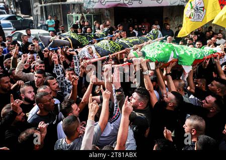 Djénine, Palestine. 17 novembre 2023. (NOTE DE l'ÉDITEUR : l'image représente la mort) les personnes en deuil portent les corps de trois Palestiniens drapés dans les drapeaux du Hamas et du Jihad islamique pendant leurs funérailles dans le camp de réfugiés de Djénine. Les forces israéliennes ont tué les trois hommes palestiniens du jihad islamique dans un raid de nuit, a déclaré vendredi le ministère palestinien de la Santé. La branche militaire du Jihad islamique palestinien a revendiqué les trois, y compris le commandant local Jamal Lahlouh, 23 ans, comme membres. (Photo de Nasser Ishtayeh/SOPA Images/Sipa USA) crédit : SIPA USA/Alamy Live News Banque D'Images