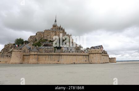 Célèbre ancienne abbaye du Mont Saint Michel au-dessus de la colline à marée basse et la muraille médiévale de la ville Banque D'Images