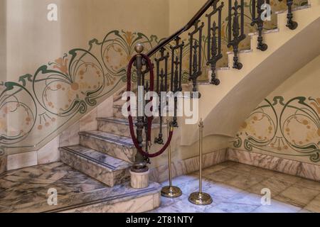 Escalier avec balustrade en fer forgé et balustrade fonctionnelle, murs décorés d'une bordure de peintures ornementales. Maison des escargots, Castello. Banque D'Images