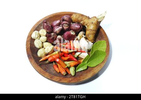 différents types d'épices de cuisine sont placés sur une plaque en bois, sur un fond blanc Banque D'Images