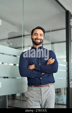 Heureux homme d'affaires indien confiant debout dans le bureau. Portrait vertical. Banque D'Images