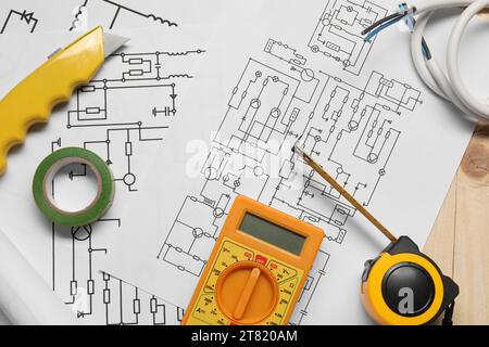 Schémas électriques, fils et multimètre numérique sur table en bois, vue de dessus Banque D'Images