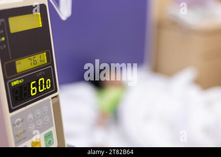 Les patients atteints de fièvre de la main de l'enfant ont un tube IV à l'hôpital. Petite fille portant le sommeil de tube IV dans la salle de lit d'urgence usi pour la leucémie coma du cancer, enfant Banque D'Images