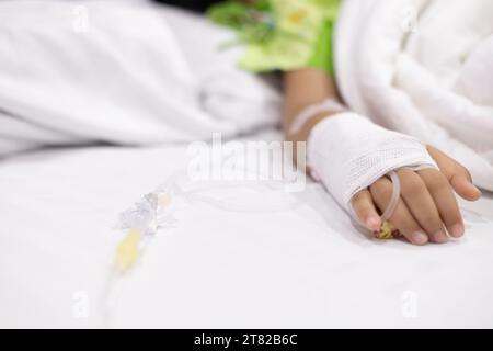 Les patients atteints de fièvre de la main de l'enfant ont un tube IV à l'hôpital. Petite fille portant le sommeil de tube IV dans la salle de lit d'urgence usi pour la leucémie coma du cancer, enfant Banque D'Images