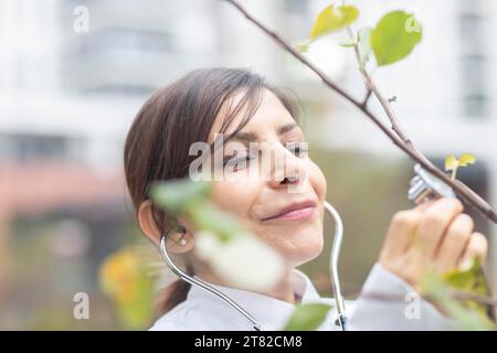 Médecin examine l'état de l'arbre avec un stéthoscope protection de l'environnement Banque D'Images