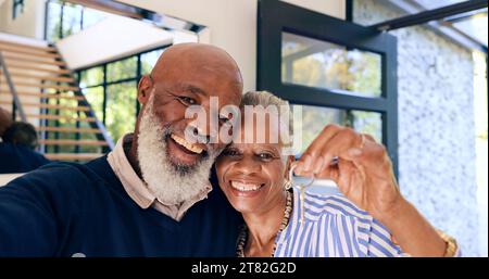 Senior, couple et portrait ou selfie et les clés de la nouvelle maison, de l'immobilier ou de l'investissement immobilier par porte d'entrée. Les Noirs, homme ou femme et sourire pour Banque D'Images