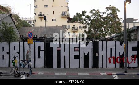 Les piétons passent devant un graffiti qui dit "ramenez-les à la maison", appelant au retour des otages arrachés par le groupe militant palestinien Hamas à Gaza dans le quartier Florentin le 17 novembre 2023 à tel Aviv, en Israël. Plus d'un mois après les attaques du Hamas du 7 octobre, l'armée du pays a poursuivi son bombardement continu de la bande de Gaza et lancé une invasion terrestre pour vaincre le groupe militant qui gouverne le territoire palestinien Banque D'Images