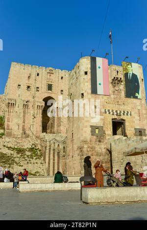 Drapeau syrien et photo de Bachar el-Assad sur la porte principale de la Citadelle d'Alep, l'un des plus anciens et des plus grands châteaux du monde Banque D'Images