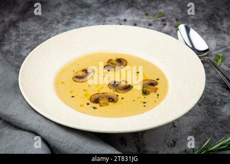 soupe à la crème aux champignons de champignons dans une assiette blanche vue de côté Banque D'Images