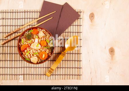 Nouilles ramen asiatiques dans un bol d'argile sur une table en bois Banque D'Images