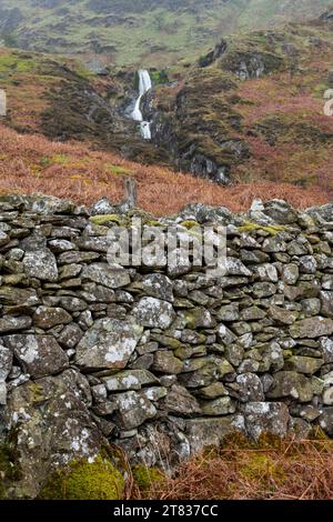 Mur traditionnel en pierres sèches dans les montagnes du nord du pays de Galles avec cascade Rhaeadr Bach en arrière-plan. Banque D'Images